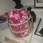 Pink velvet handbag with pearl details on a surface