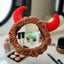 Brown scrunchie with red devil horns on a magazine background