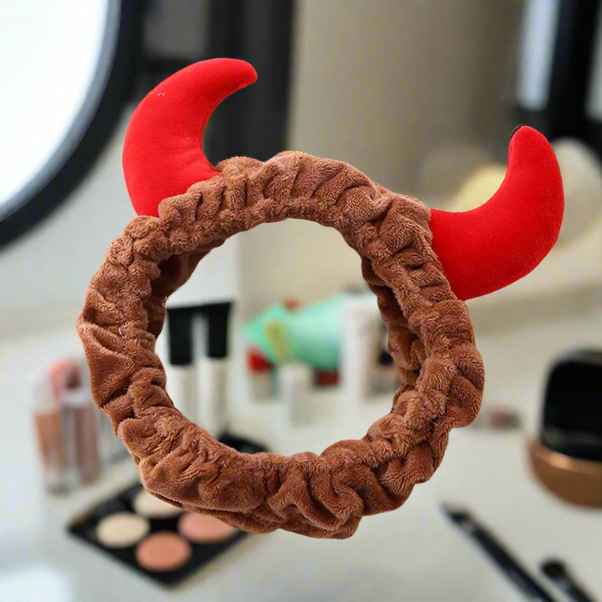 Brown scrunchie with red devil horns on a magazine background